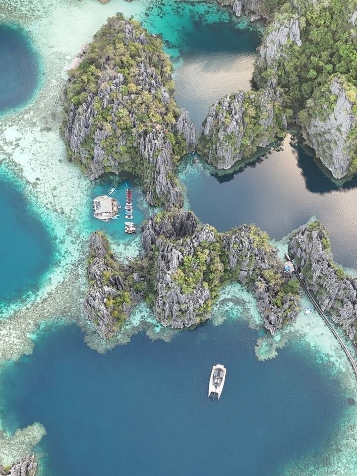 A catamaran in a limestone lagoon, straight down from the air