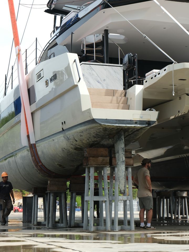 A catamaran's stern on stands with the rudder showing