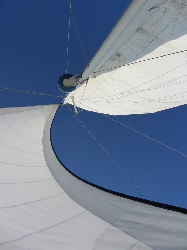 Looking straight up at a sail against a deep blue sky