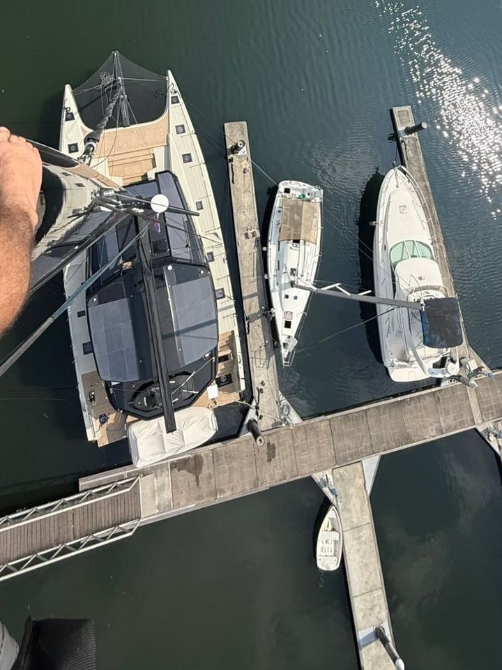 Looking down from the top of the mast at a catamaran in its marina berth