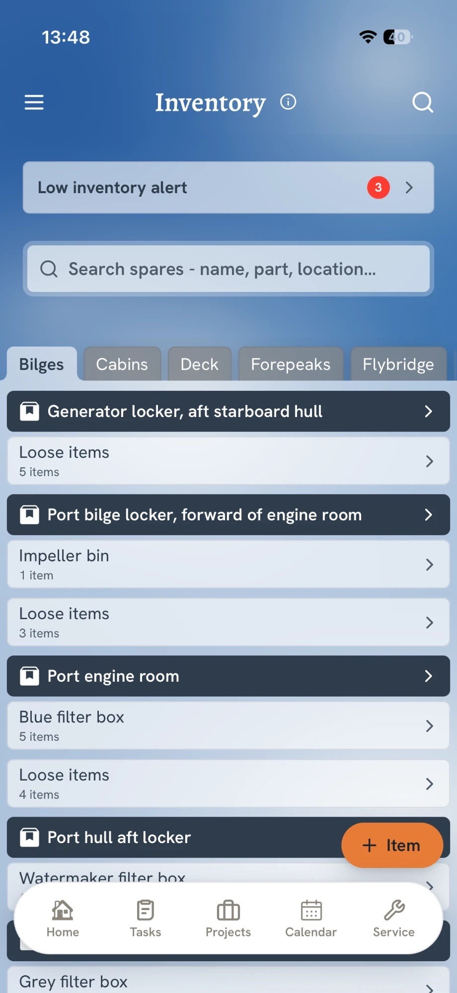 The Inventory screen in the app: a low inventory alert, a search bar, location tabs such as bilges, cabins and deck, and spares grouped by locker